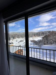 a window with a view of a snow covered field at X2 4Rest Bakuriani in Bakuriani