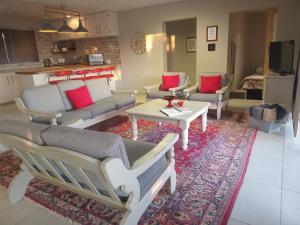 a living room with couches and a table on a rug at OppiDam Gastehuis in Vanderkloof