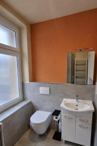 a bathroom with a white toilet and a sink at Casa Mateo - Mediterranean Studio in Bielefeld +10 photos