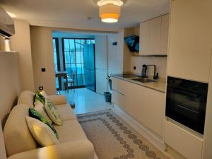 a living room with a couch and a kitchen at Baykus Deluxe in Kuşadası