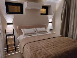 a bedroom with a large bed with two lights on it at Baykus Deluxe in Kuşadası