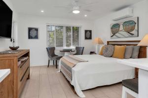 a bedroom with a bed and a desk and a television at Charming Studio w Pool One Mile to Beach Pets Welcome in Lake Worth