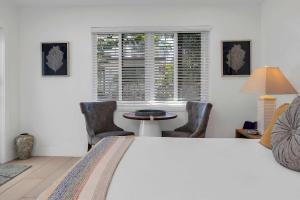 a bedroom with a bed and a table and chairs at Charming Studio w Pool One Mile to Beach Pets Welcome in Lake Worth