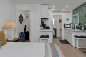 a bedroom with a bed and a kitchen with a counter at Charming Studio w Pool One Mile to Beach Pets Welcome in Lake Worth +27 photos