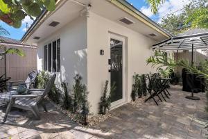 a patio with chairs and a table and an umbrella at Charming Studio w Pool One Mile to Beach Pets Welcome in Lake Worth