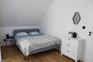 a bedroom with a bed and a white dresser at Šťastná 118 in Sněžné