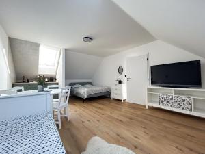 a living room with a flat screen tv and a bedroom at Šťastná 118 in Sněžné