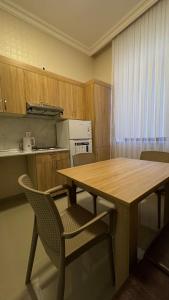 a kitchen with a wooden table and chairs at RAA apartments in Qusar