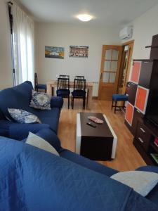 a living room with a blue couch and a table at Luz de la Avenida in Tomelloso