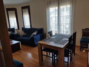 a living room with a table and a blue couch at Luz de la Avenida in Tomelloso
