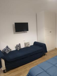 a living room with a blue couch and a flat screen tv at La Casa delle Onde B&B in Pescara