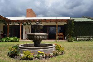 a fountain in a yard in front of a house at Casa del Viajero in Pifo