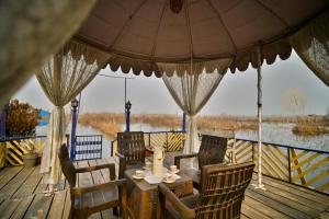 a wooden deck with a table and chairs and an umbrella at Dolphin houseboat in Srinagar