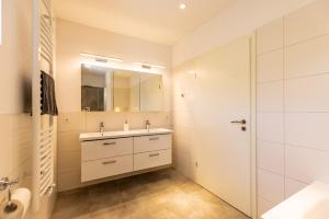 a white bathroom with a sink and a shower at Die Schlafstube - Boutiquehotel in Neuharlingersiel +31 photos