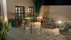 a room with a glass table and some plants at Riad Dar Chaafa 17 in Salé +27 photos