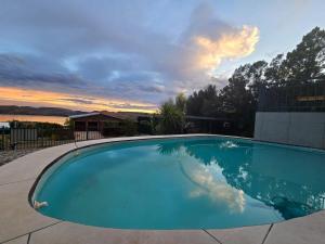 a large swimming pool with a sunset in the background at OppiDam Gastehuis in Vanderkloof