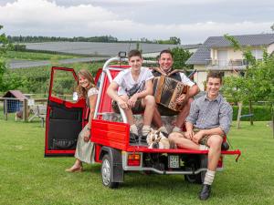 a group of people sitting in the back of a red truck at Obst- und Ferienhof Gomeringer in Immenstaad am Bodensee