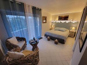 a bedroom with a bed and a chair and a window at Les Pertuis Rochelais in Périgny +60 photos