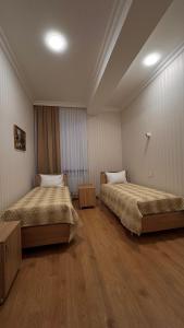 a room with two beds in a room at RAA apartments in Qusar