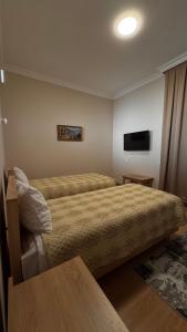 a hotel room with a bed and a television at RAA apartments in Qusar +48 photos