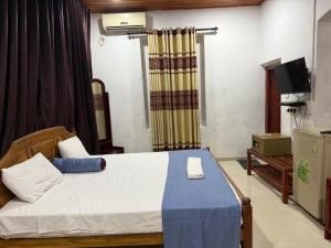a bedroom with a bed and a television in it at Peninsula hotel in Jaffna