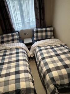 a bedroom with two beds and a window at Tulip 10, Oakdene Forest Park , passes included in Saint Leonards +33 photos