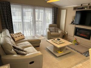 a living room with a couch and a table and a tv at Tulip 10, Oakdene Forest Park , passes included in Saint Leonards