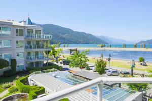 a view of the beach from a balcony of a resort at Lakefront Haven Mtn View Condo Steps from Beach in Harrison Hot Springs