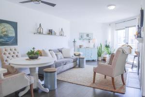 a living room with a couch and a table and chairs at Lakefront Haven Mtn View Condo Steps from Beach in Harrison Hot Springs