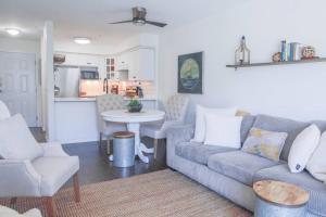 a living room with a couch and a table and a kitchen at Lakefront Haven Mtn View Condo Steps from Beach in Harrison Hot Springs +27 photos