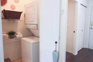 a bathroom with a sink and a washing machine at Lakefront Haven Mtn View Condo Steps from Beach in Harrison Hot Springs