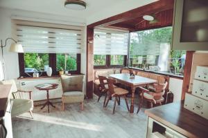 a dining room with a table and chairs and windows at Ferienhaus Vogtland mit Sauna und Hot Tub in Weischlitz