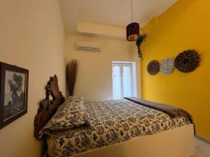 a bedroom with a bed in a room with yellow walls at Porto Antico in Bari