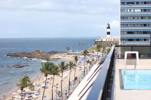 a view of a beach with a lighthouse and the ocean at Flat Farol da Barra 2 in Salvador