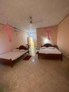 two beds in a room with pink decorations on the ceilings at Mayura Beach Resort Matara in Matara