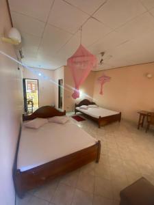 a bedroom with two beds in a room at Mayura Beach Resort Matara in Matara +4 photos