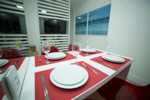una mesa con platos blancos y copas de vino. en Flat Farol da Barra 2, en Salvador