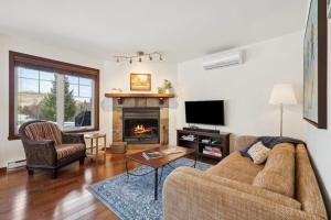 a living room with a couch and a fireplace at Cozy Golfside Oasis Fireplace and Terrace in Mont-Tremblant