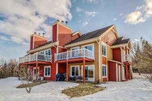 a large red house in the snow at Cozy Golfside Oasis Fireplace and Terrace in Mont-Tremblant
