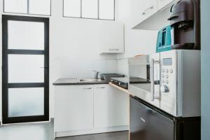 a kitchen with white cabinets and a stainless steel appliances at Studio - Normandy 1 in Le Havre +10 photos