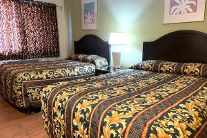 a hotel room with two beds and a lamp at Sun Star Inn Los Banos in Los Banos +7 photos