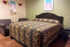 a bedroom with a bed with a blanket on it at Sun Star Inn Los Banos in Los Banos