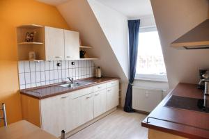 a small kitchen with a sink and a window at Lagunenstadt am Haff - Fewo 67 Vorstag in Ueckermünde +15 photos