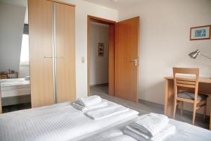 a bedroom with a bed and a desk and a chair at Lagunenstadt am Haff - Fewo 67 Vorstag in Ueckermünde
