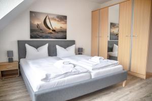 a bedroom with a large bed with white sheets at Lagunenstadt am Haff - Fewo 67 Vorstag in Ueckermünde