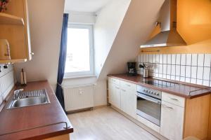 a small kitchen with a sink and a stove at Lagunenstadt am Haff - Fewo 67 Vorstag in Ueckermünde