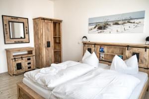 a bedroom with a large bed with white sheets at Bungalow Klüver in Ueckermünde +14 photos