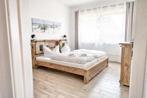 a bedroom with a bed with white sheets and a window at Bungalow Klüver in Ueckermünde