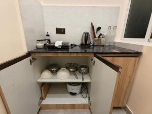 a small kitchen with a counter with pots and pans at Cordial Host in Guwahati