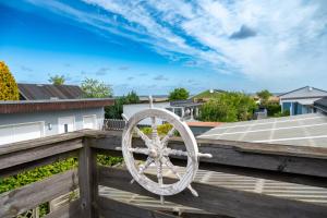 a wooden railing with a wheel on a deck at Mö 71-Inselblick in Mönkebude